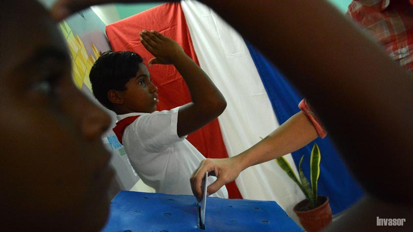 Niños saludando al momento de la votación