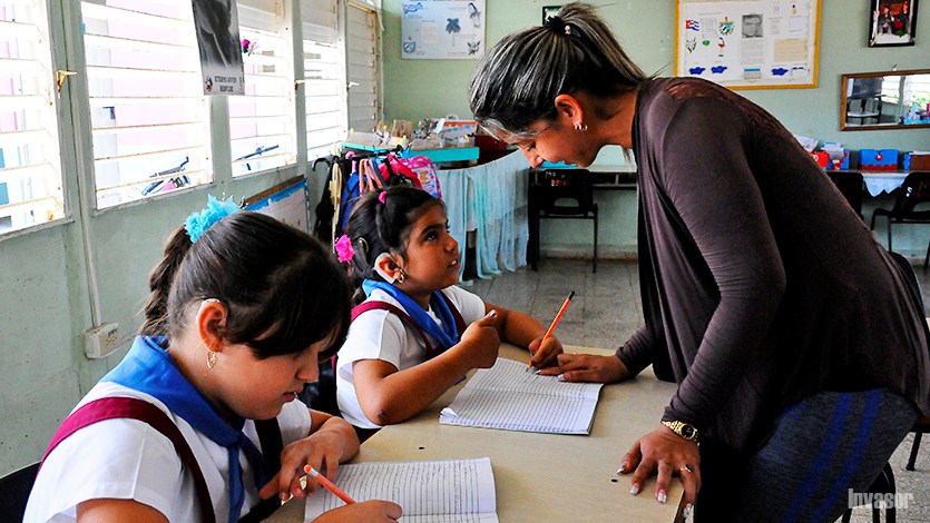 Maestra enseñando a sus alumnas con discapacidades auditivas