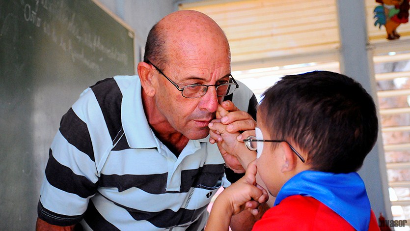 El Director de la escuela enseñando a uno de los niños