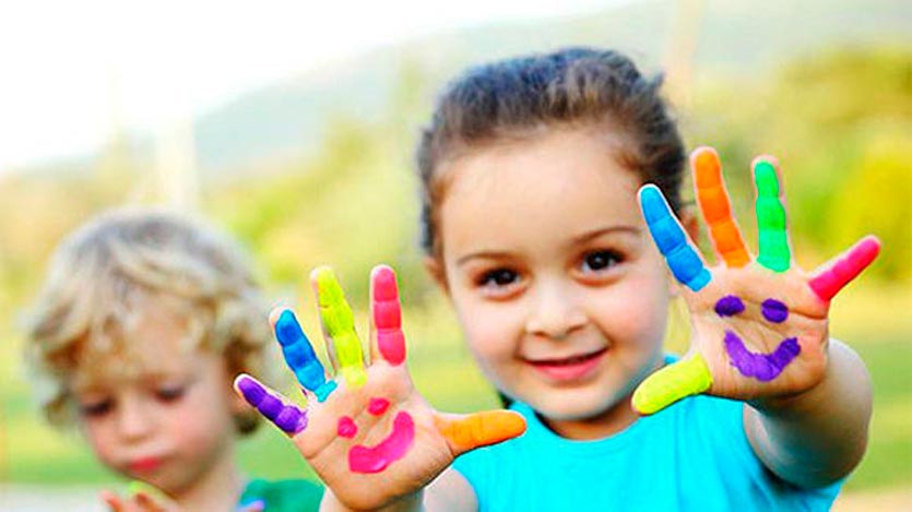 Niña con sus manos pintadas de colores