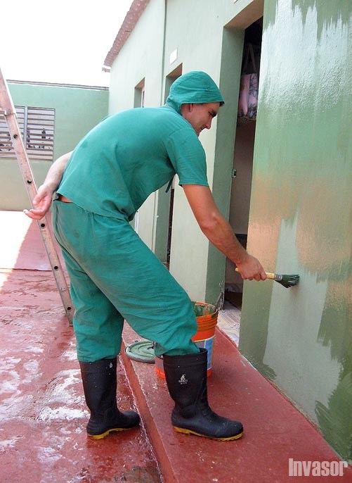 Trabajador pintando una pared