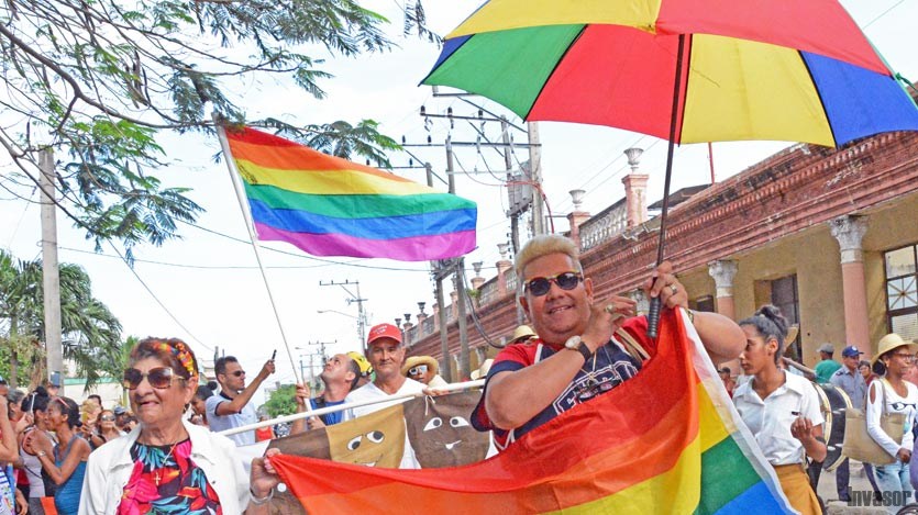 Personas con banderas y sombrillas de colores
