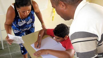 Adultos enseñando a un niño en la escritura