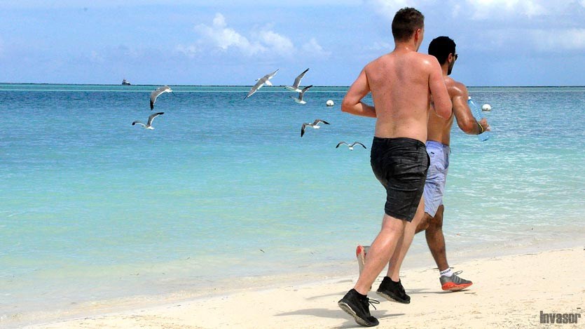 Hombres corriendo en la playa