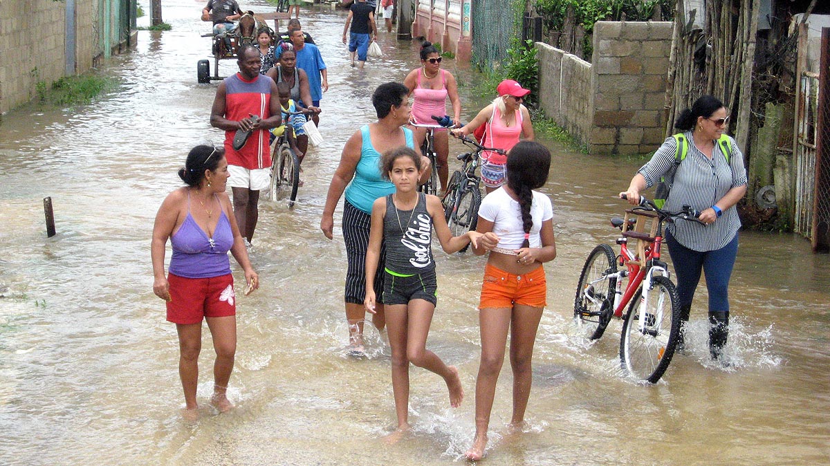 Personas transitando por calle inundada