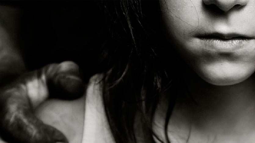 Niña con la mano de un hombre en su hombro