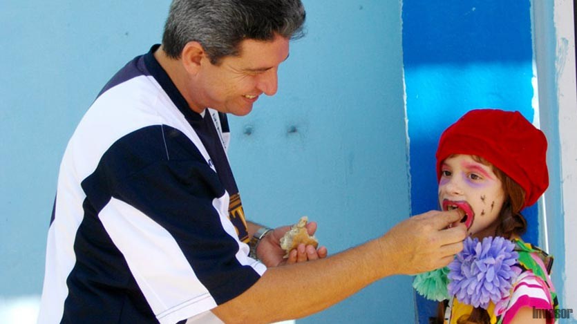 Padre dando de comer a su niña