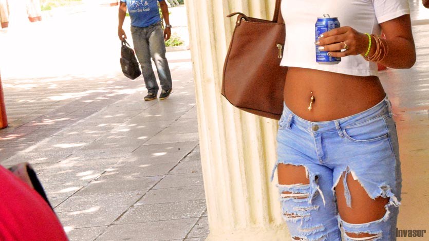 Muchacha con pantalones rotos y piercing