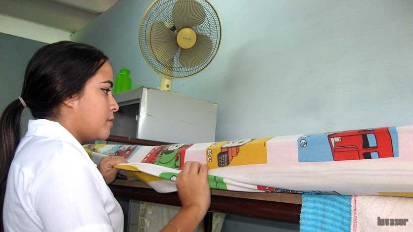 Jovencita arreglando su cama