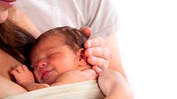 Niño pequeño en pechos de su madre