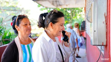 Mujer llamando por teléfono público