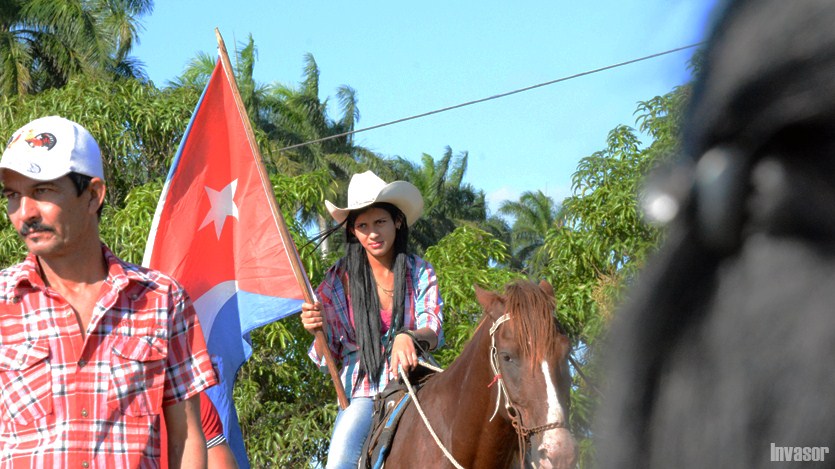 Mujer montada a caballo, bandera al fondo