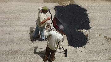 Hombres reparan bache