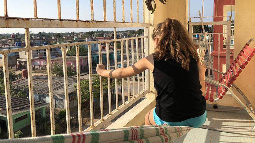 Niña sentada en el balcón